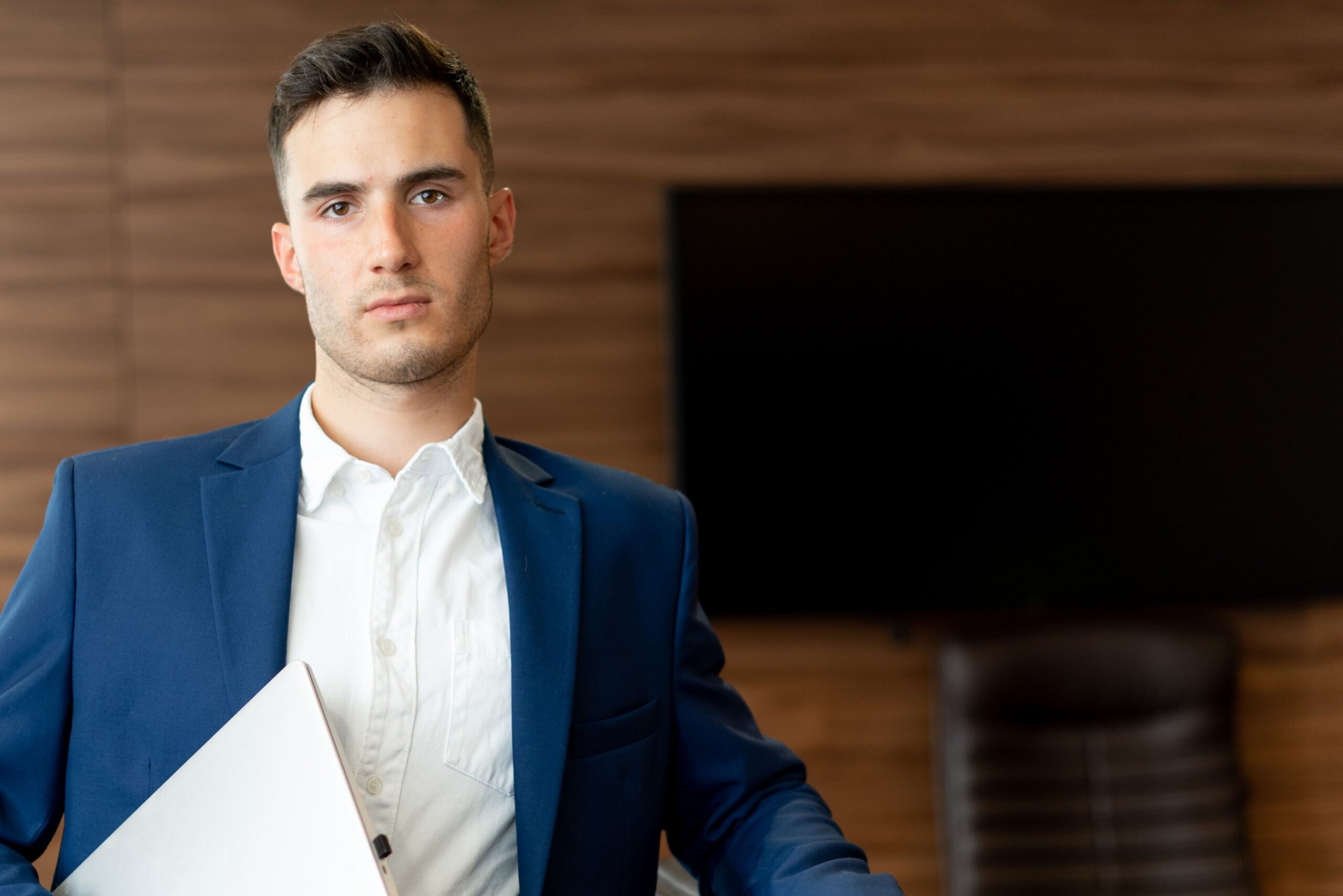 pexels-mikhail-nilov-8937609 a man standing with a laptop